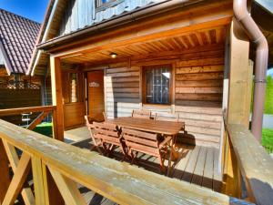 een houten terras met een houten tafel en banken bij Holiday home in Ustronie Morskie with a playground in Ustronie Morskie