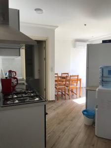 a kitchen with a stove and a kitchen with chairs at Leman Apart in Bodrum City