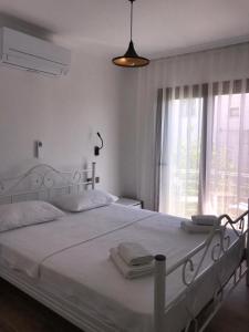 um quarto branco com uma cama grande e lençóis brancos em Leman Apart em Bodrum City
