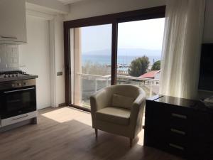 a living room with a chair and a large window at Leman Apart in Bodrum City
