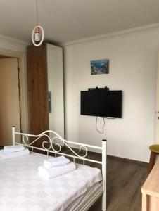 a bedroom with a bed with a tv on the wall at Leman Apart in Bodrum City