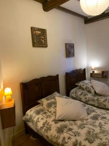 a bedroom with two beds and a table with a lamp at Le gîte du chateau dans le centre de schirmeck in Schirmeck +43 photos