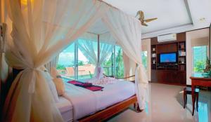 a bedroom with a white canopy bed with a window at Samui Sunrise Seaview Villa in Chaweng +37 photos