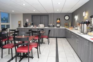 a restaurant with a bar and tables and chairs at Red Roof Inn Batavia in Batavia