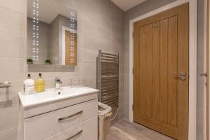 a bathroom with a sink and a mirror at Rutland Heights,A Fantastic Modern Coastal House, Sea Views, Garden, Terraces, 2x Allocated Private Parking Spaces plus Free Private use of Electric Vehicle Point Meadfoot Beach only 5mins away! Also Shops, Bars and Restaurants just a 10 minute walk! in Torquay