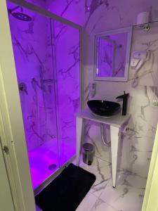 a bathroom with a sink and a shower with purple lighting at B&B Rial in Naples