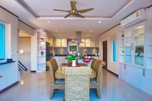 comedor con mesa con sillas y ventilador de techo en Samui Sunrise Seaview Villa en Chaweng