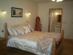 a bedroom with a large bed and a bathroom at Derry House in Listowel