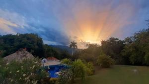 einen Regenbogen am Himmel über einem Pool in der Unterkunft Hostal finca Palermo in Santa Fe de Antioquia