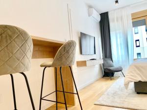 1 dormitorio con silla, 1 cama y TV en Bulevard57 en Belgrado