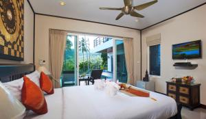 a bedroom with a large white bed with a ceiling fan at Samui Sunrise Seaview Villa in Chaweng