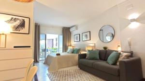 a living room with a couch and a bed at Al-Charb Studio in Quarteira