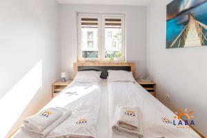 Posteľ alebo postele v izbe v ubytovaní LABA Kołobrzeg Apartamenty BURSZTYNOWE z miejscami postojowymi