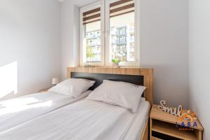 Posteľ alebo postele v izbe v ubytovaní LABA Kołobrzeg Apartamenty BURSZTYNOWE z miejscami postojowymi