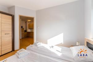 Posteľ alebo postele v izbe v ubytovaní LABA Kołobrzeg Apartamenty BURSZTYNOWE z miejscami postojowymi