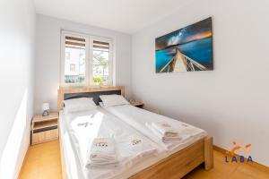 Posteľ alebo postele v izbe v ubytovaní LABA Kołobrzeg Apartamenty BURSZTYNOWE z miejscami postojowymi