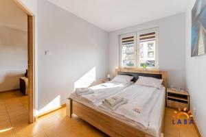 Posteľ alebo postele v izbe v ubytovaní LABA Kołobrzeg Apartamenty BURSZTYNOWE z miejscami postojowymi