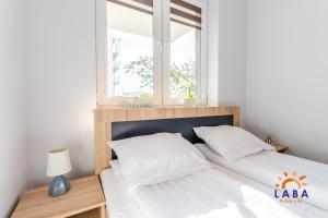 Posteľ alebo postele v izbe v ubytovaní LABA Kołobrzeg Apartamenty BURSZTYNOWE z miejscami postojowymi + 37 fotografií