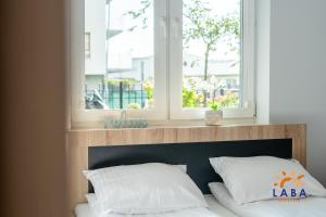 Posteľ alebo postele v izbe v ubytovaní LABA Kołobrzeg Apartamenty BURSZTYNOWE z miejscami postojowymi