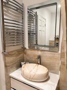 baño con lavabo circular y espejo en Luxurious double bedroom, ensuite with free Wifi. en Oxford