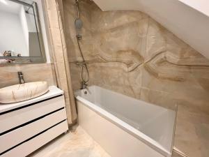 a bathroom with a white tub and a sink at Luxurious double bedroom, ensuite with free Wifi. in Oxford