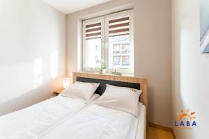 Posteľ alebo postele v izbe v ubytovaní LABA Kołobrzeg Apartamenty BURSZTYNOWE z miejscami postojowymi