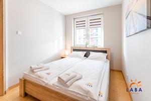 Posteľ alebo postele v izbe v ubytovaní LABA Kołobrzeg Apartamenty BURSZTYNOWE z miejscami postojowymi