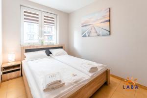Posteľ alebo postele v izbe v ubytovaní LABA Kołobrzeg Apartamenty BURSZTYNOWE z miejscami postojowymi