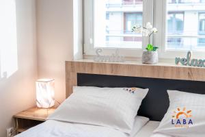Posteľ alebo postele v izbe v ubytovaní LABA Kołobrzeg Apartamenty BURSZTYNOWE z miejscami postojowymi