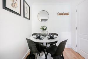 a white dining room with a white table and chairs at Stunning 2 bedroom next to City Centre in Liverpool