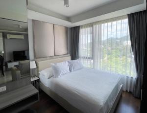 a bedroom with a bed and a large window at 6th Avenue Surin by Lofty in Surin Beach