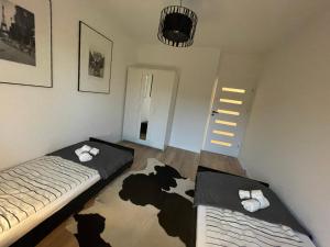 a room with two beds and a cow rug on the floor at Apartament Park Poezji in Gliwice