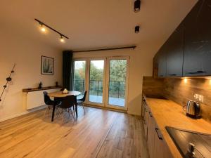 a kitchen with a table and chairs and a window at Apartament Park Poezji in Gliwice