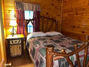 een slaapkamer met een bed in een blokhut bij Hominy Ridge Cabins and Gift Shop in Sigel