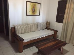 a couch in a living room with a table at Paradise Chalés Beira Mar in Barra do Cunhau