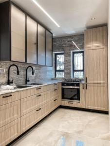 a kitchen with wooden cabinets and stainless steel appliances at KOTEL HOTEL in Jerusalem