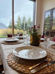 a table with a plate on a table with a window at House with a magical garden and sunroom in Höfn