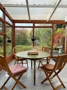 eine abgeschirmte Veranda mit einem Tisch und Stühlen in der Unterkunft House with a magical garden and sunroom in Höfn