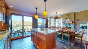 a kitchen with a table and a dining room at Golf Course & Mountain Views by Harmony Whistler in Whistler