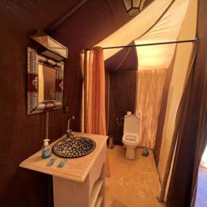 a bathroom with a sink and a toilet in a tent at Fabulous Desert Camp in Merzouga