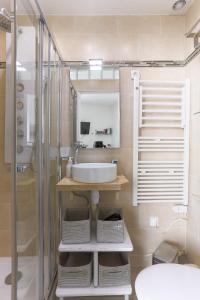 een badkamer met een wastafel en een douche bij RASPAIL Cozy Flat in Parijs