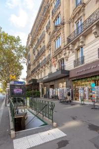 un autobús está estacionado frente a un edificio en RASPAIL Cozy Flat en París