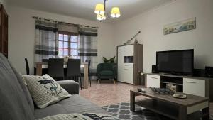 een woonkamer met een bank, een tv en een tafel bij West coast dream Nazare in Nazaré
