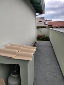 un balcón con un banco en el lateral de un edificio en Casa completa, simples e aconchegante em Urubici., en Urubici