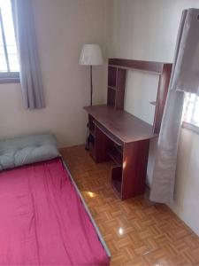 einen Schreibtisch in einem Zimmer mit einem Bett und einem Schreibtisch in der Unterkunft Balili Property at Metro Manila Hills Subd Rodriguez Rizal in Manila