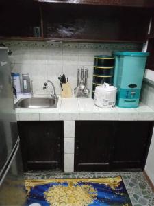 a kitchen counter with a sink and utensils at Balili Property at Metro Manila Hills Subd Rodriguez Rizal in Manila