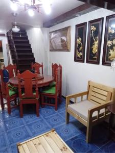 Balili Property at Metro Manila Hills Subd Rodriguez Rizal في مانيلا: غرفة طعام مع طاولة وكراسي وسلالم