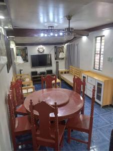 a dining room with a table and chairs and a tv at Balili Property at Metro Manila Hills Subd Rodriguez Rizal in Manila
