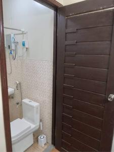 a bathroom with a toilet and a wooden door at Balili Property at Metro Manila Hills Subd Rodriguez Rizal in Manila +73 photos