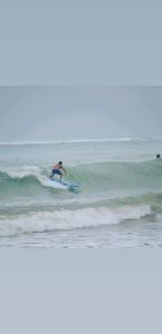 a man riding a wave on a surfboard in the ocean at Rincon Dorms in Rincon